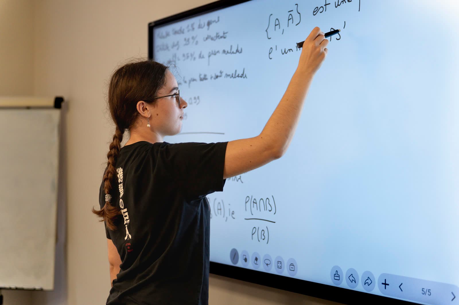 Une élève écrit une formule de probabilités au tableau.